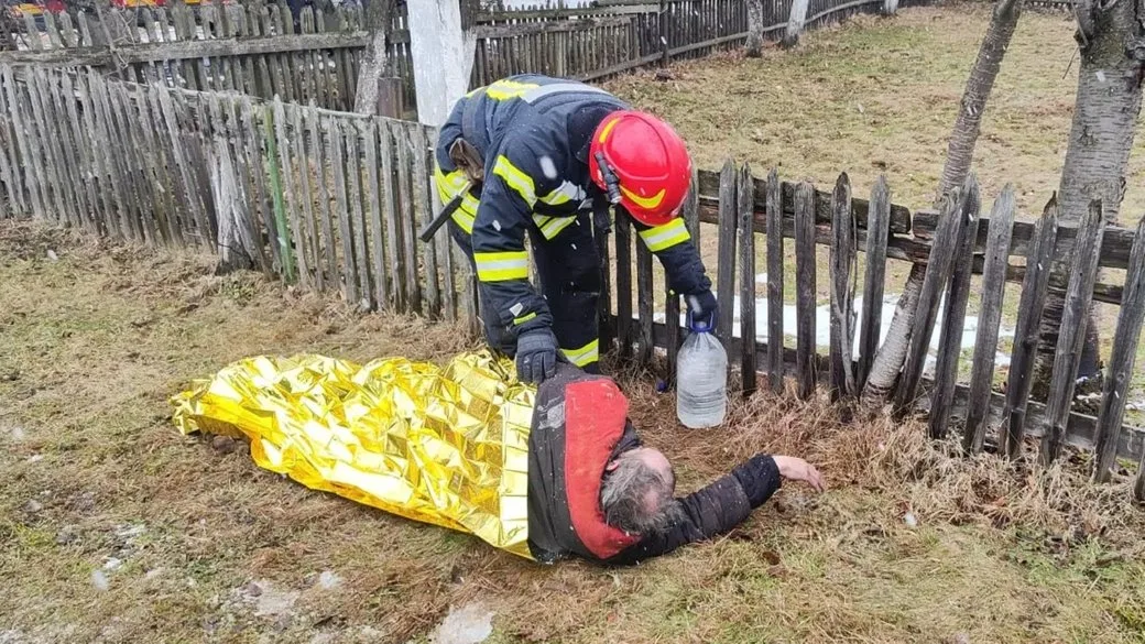 Рятувальник допомагає чоловікові, загорнутому в термоковдру