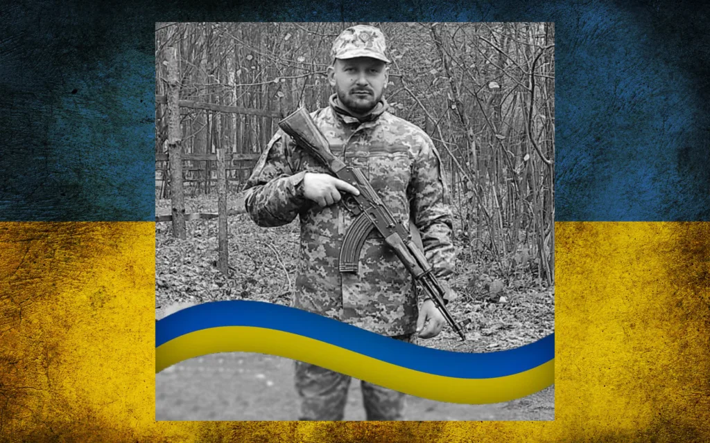 Український військовий у камуфляжі з прапором України