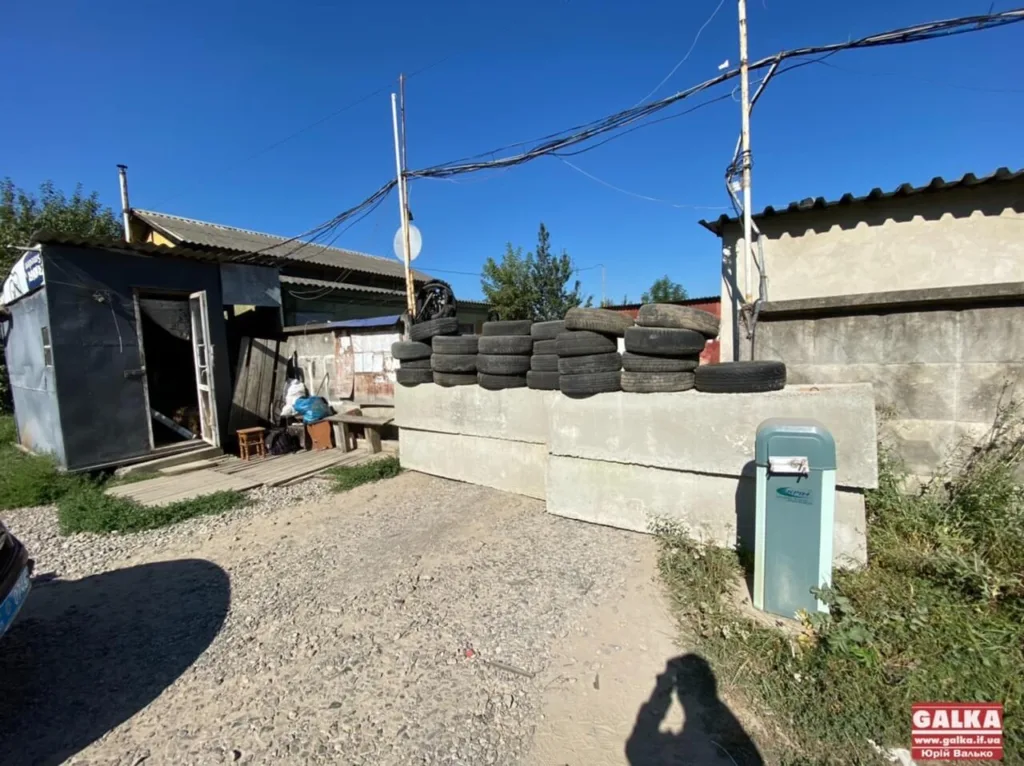 Стара будівля з шинами та бетонною стіною