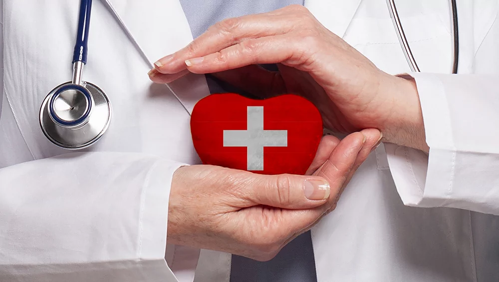 Лікар тримає серце з медичним хрестом