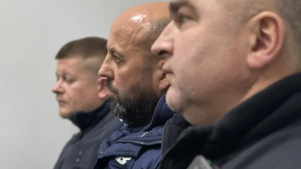 Троє чоловіків у профіль у темному одязі