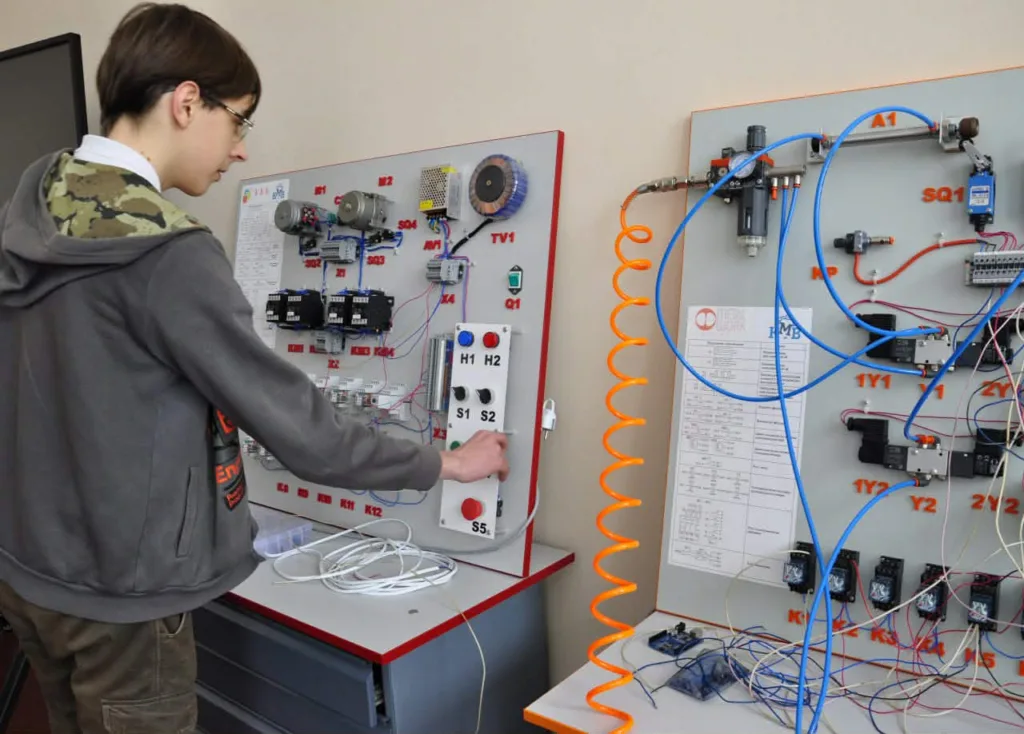 Студент працює з електротехнічним навчальним стендом
