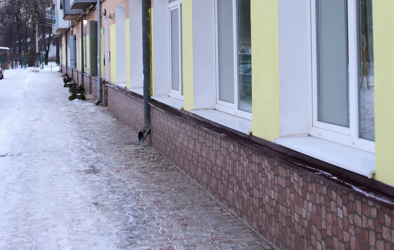 Засніжена вулиця біля житлового будинку