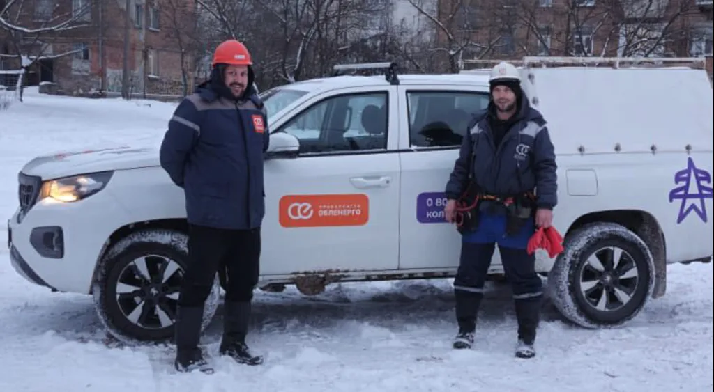 Працівники енергетичної компанії біля службового автомобіля