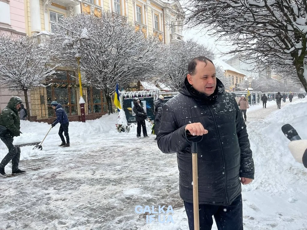 Люди прибирають сніг на зимовій вулиці міста