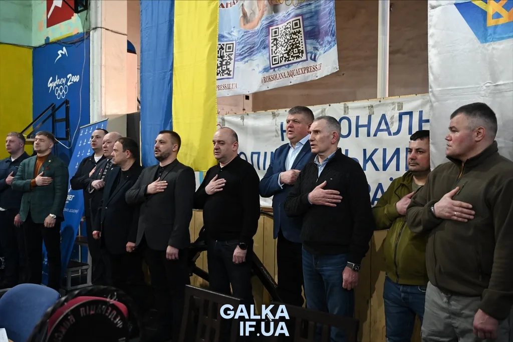 Чоловіки стоять під час гімну України