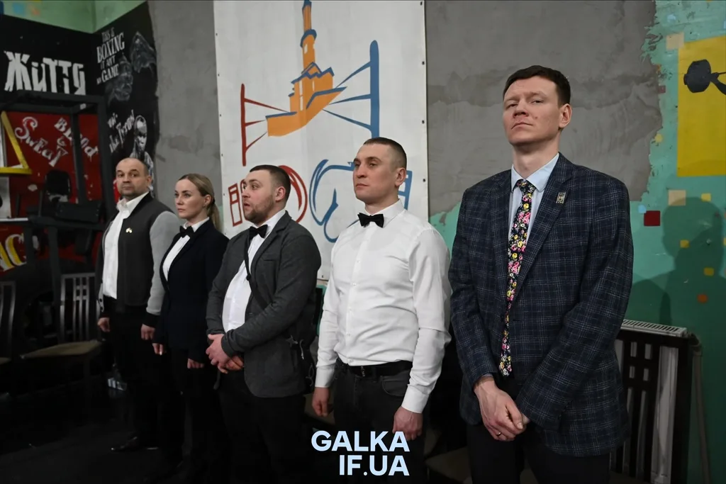 Група людей стоїть перед банером у приміщенні