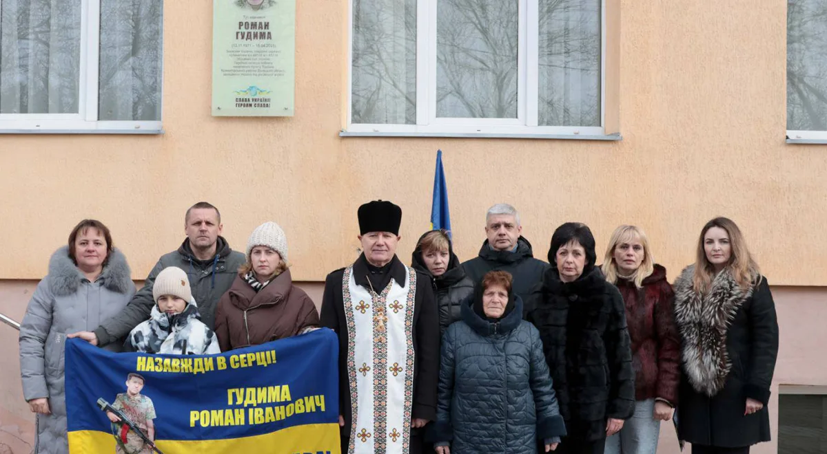 Люди біля меморіальної дошки Герою України