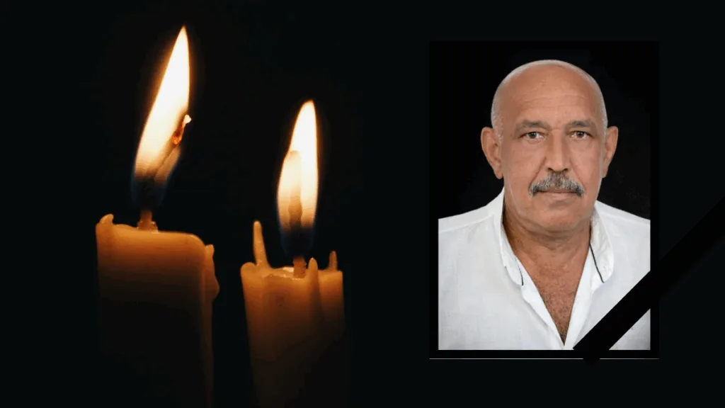 Дві свічки та фото чоловіка у жалобі