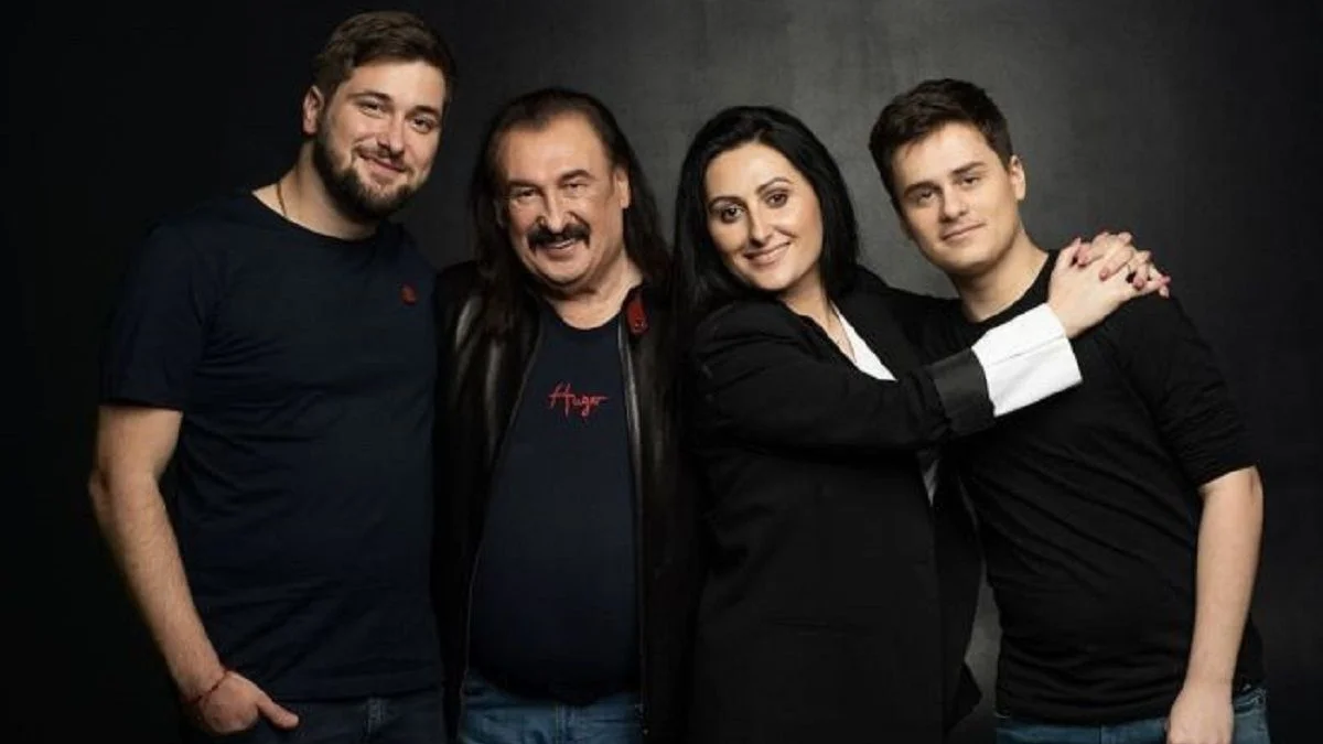 Чотири людини позують разом на темному фоні