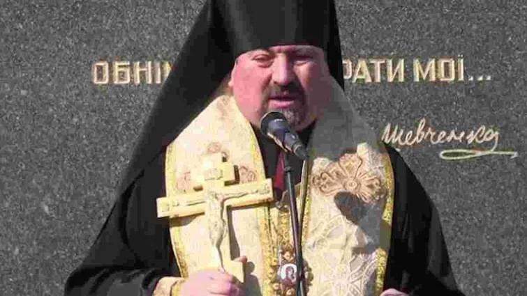 Священник тримає хрест під час церемонії