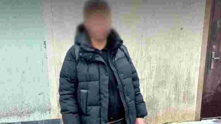 Людина в чорній куртці стоїть біля стіни