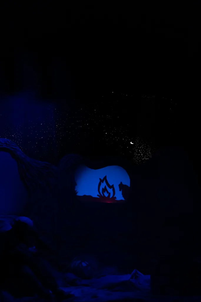 Театральна сцена з блакитним освітленням і силуетами