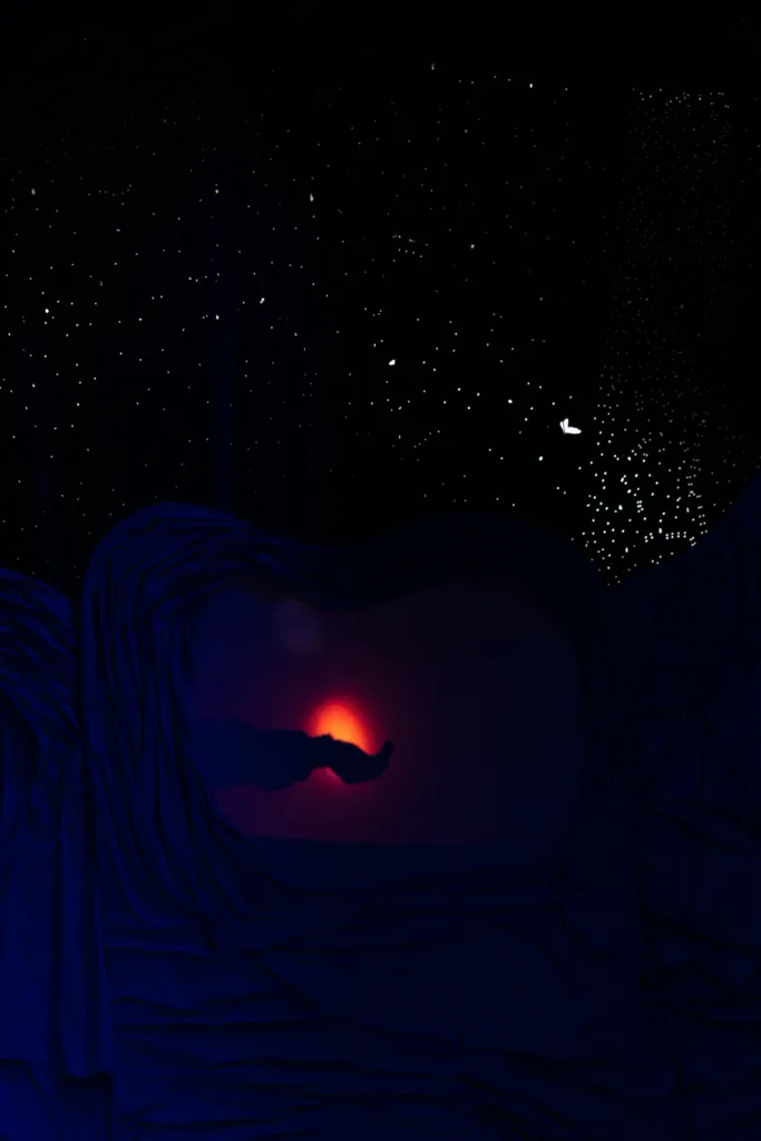 Силует руки перед червоним світлом у темряві