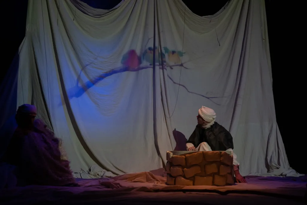 Театральна сцена з актором біля колодязя