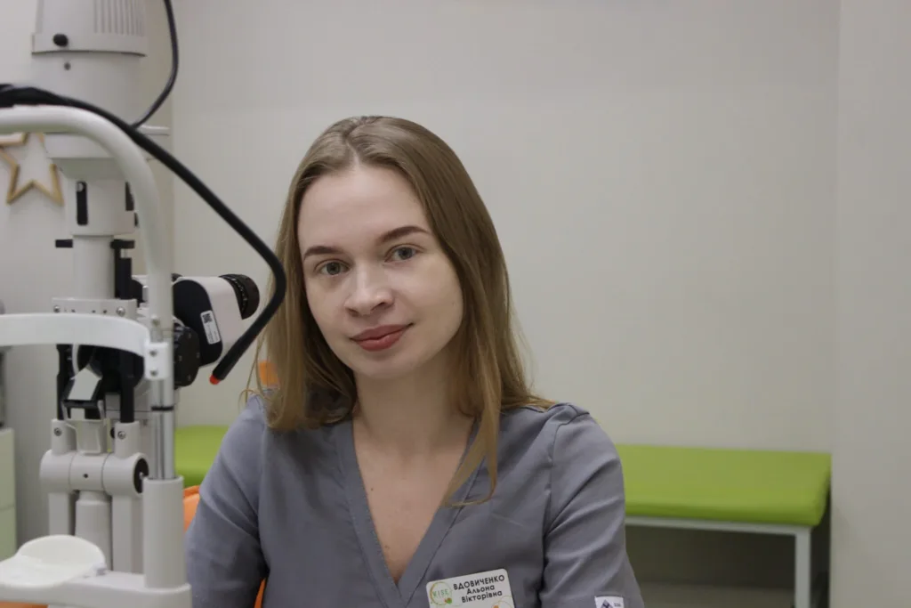 Жінка-офтальмолог у кабінеті біля обладнання