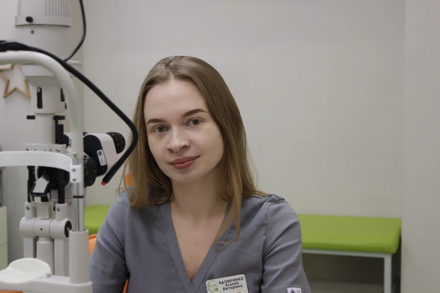 Жінка-офтальмолог у кабінеті біля обладнання