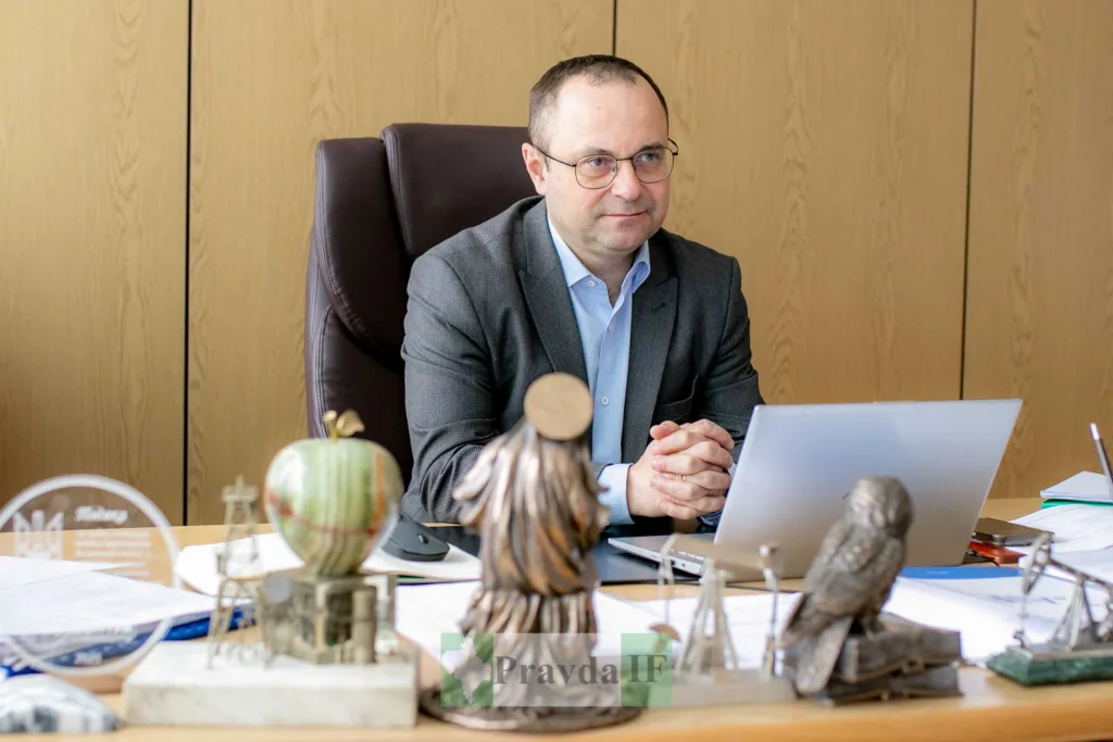 Чоловік у діловому костюмі сидить за ноутбуком