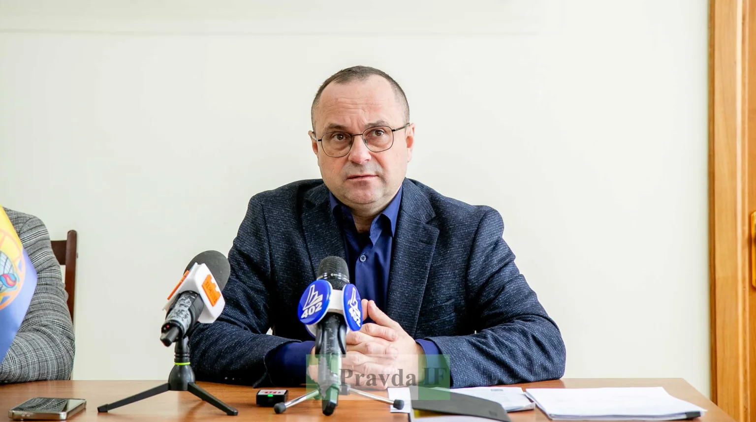 Чоловік на пресконференції з мікрофонами