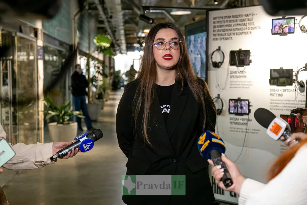 Жінка дає інтерв'ю журналістам у сучасному приміщенні