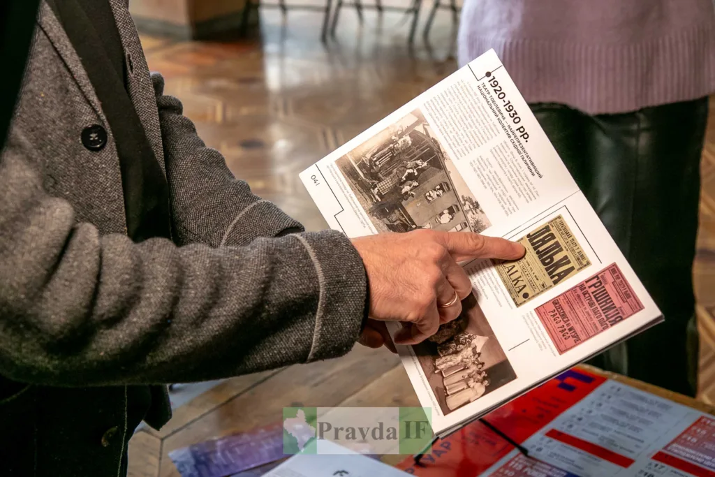 Людина переглядає історичний журнал зі старими фото