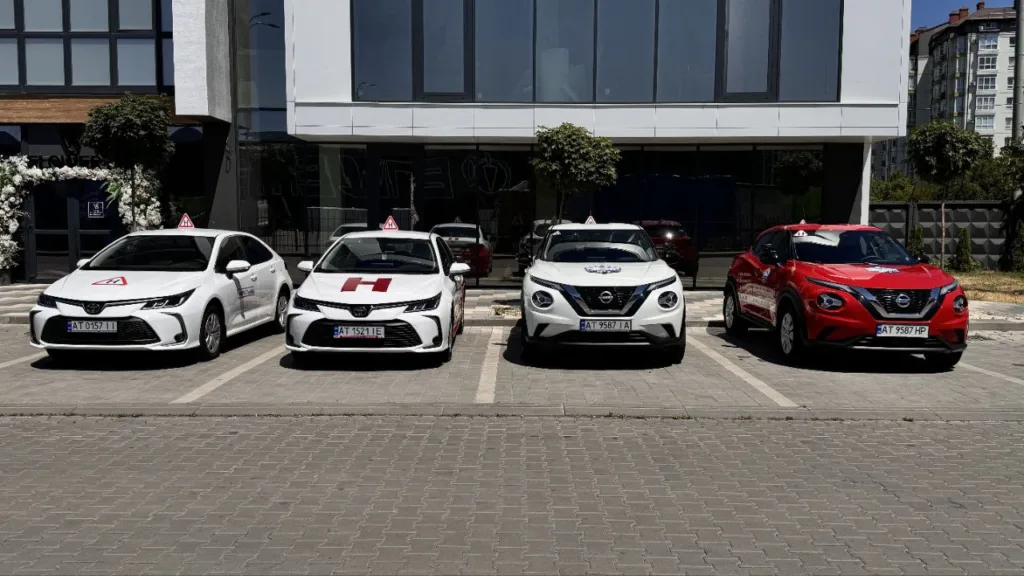 Автомобілі автошколи припарковані перед будівлею