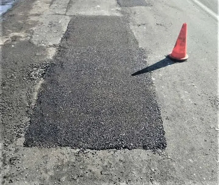 Ремонт асфальту на дорозі з конусом
