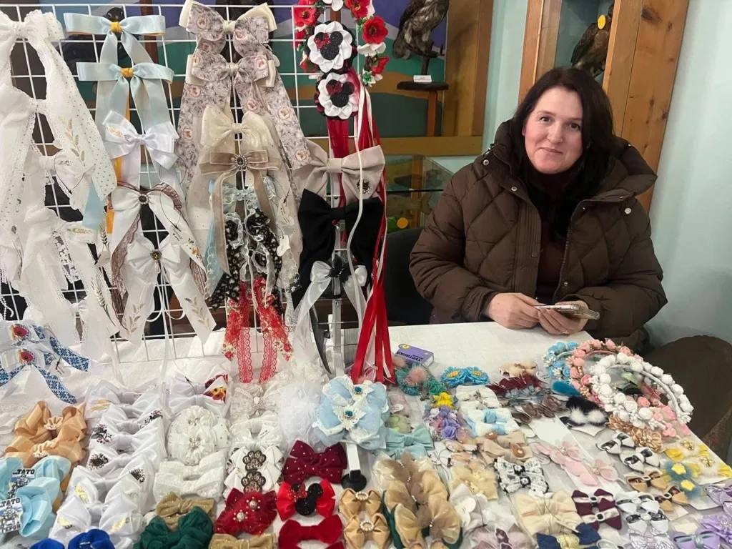 Жінка продає різнокольорові банти та прикраси