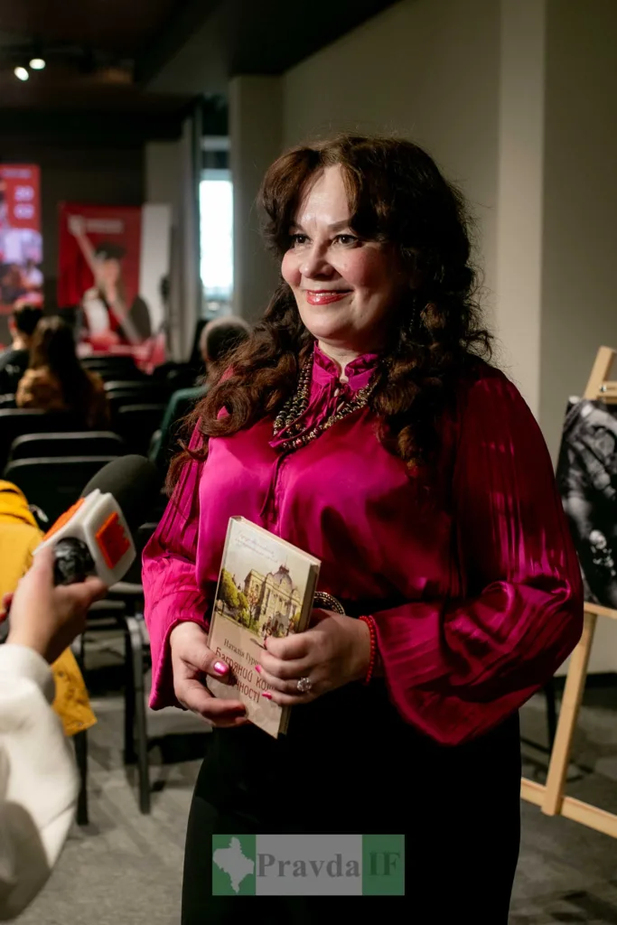 Жінка тримає книгу на літературному заході