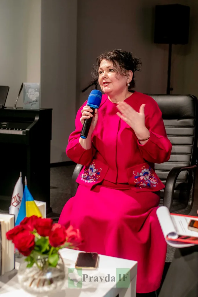 Жінка у рожевому говорить на публічному заході