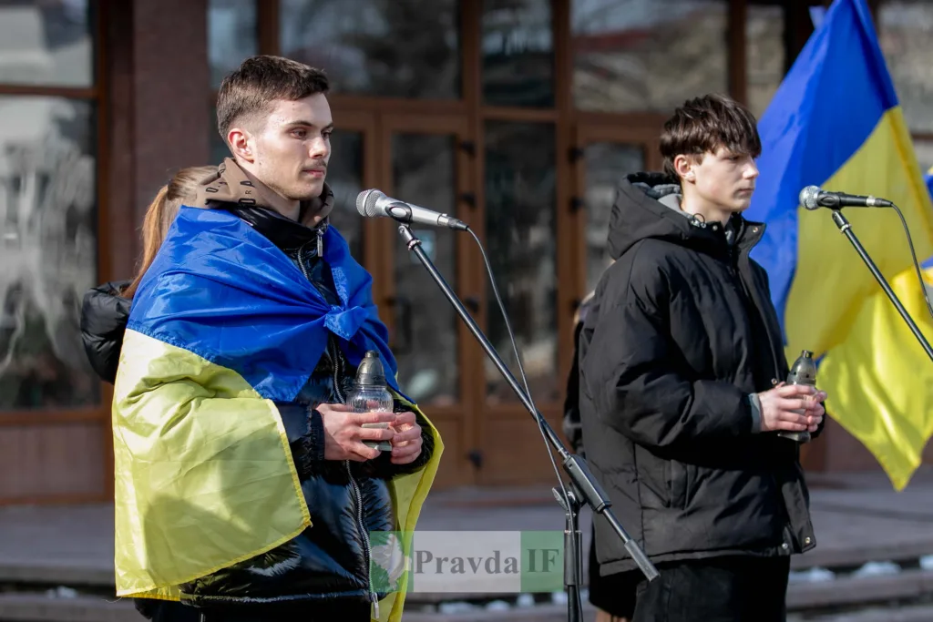 Молодь з українським прапором на вуличному мітингу