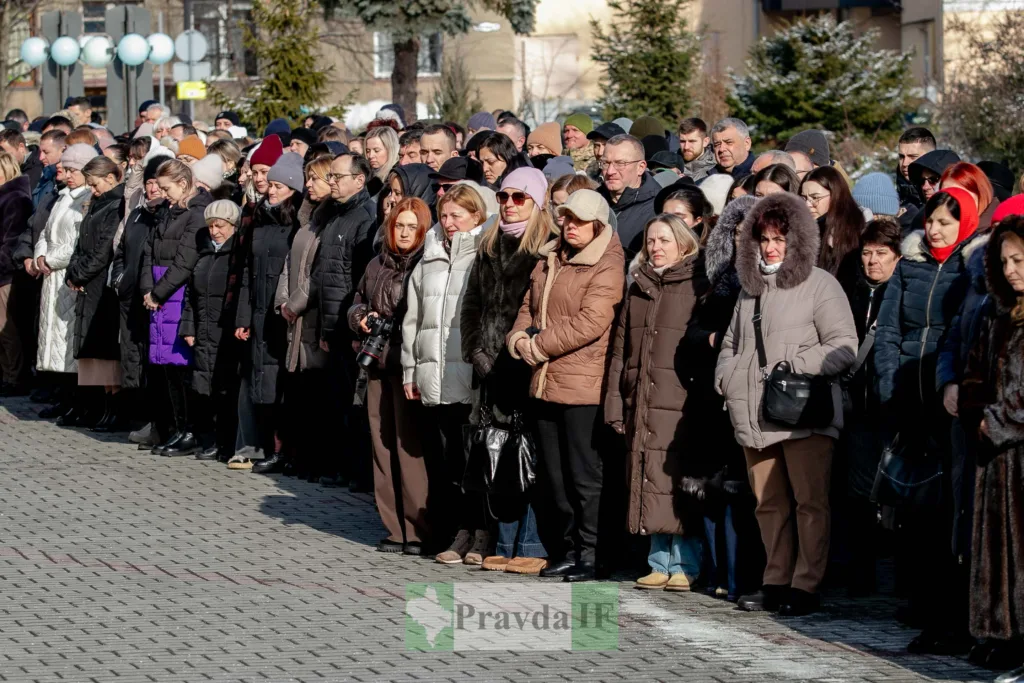 Люди стоять на вулиці під час заходу взимку