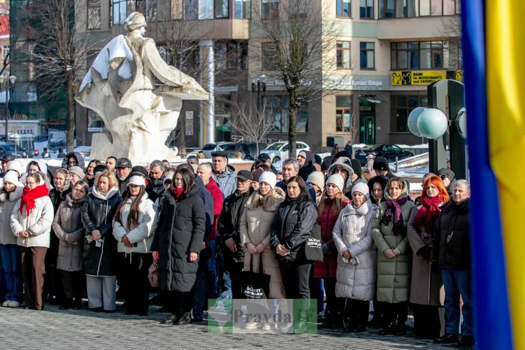 Люди на мітингу біля пам’ятника взимку