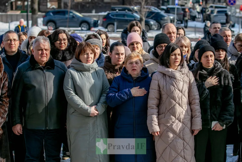 Люди стоять під час урочистого заходу взимку