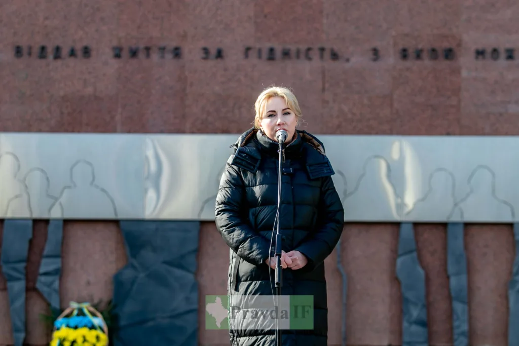 Жінка виступає біля пам’ятника у місті