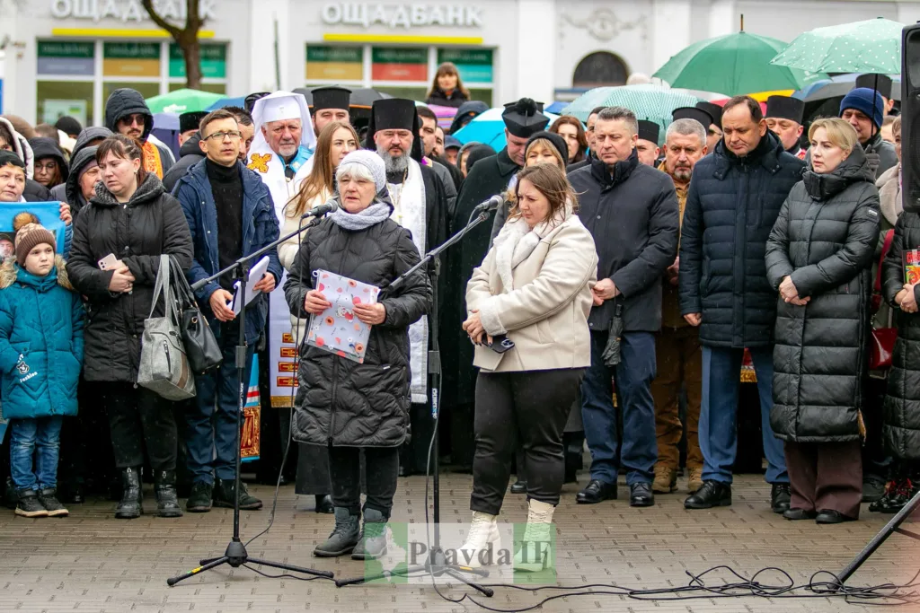 Люди на вуличному заході під дощем з парасолями