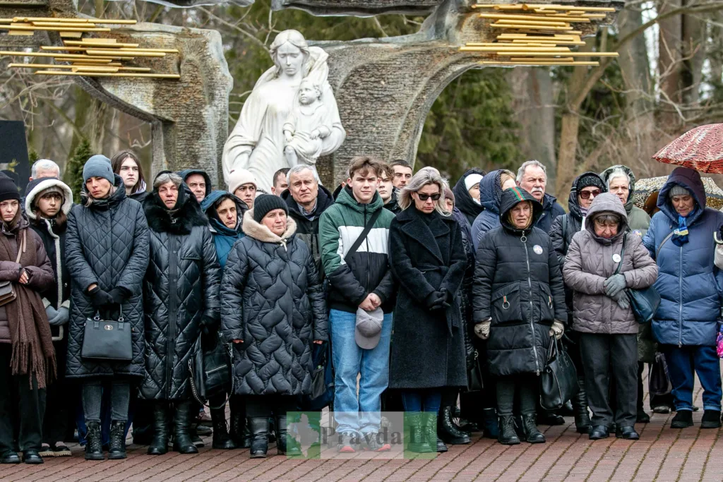Люди вшановують пам’ять біля пам’ятника на вулиці