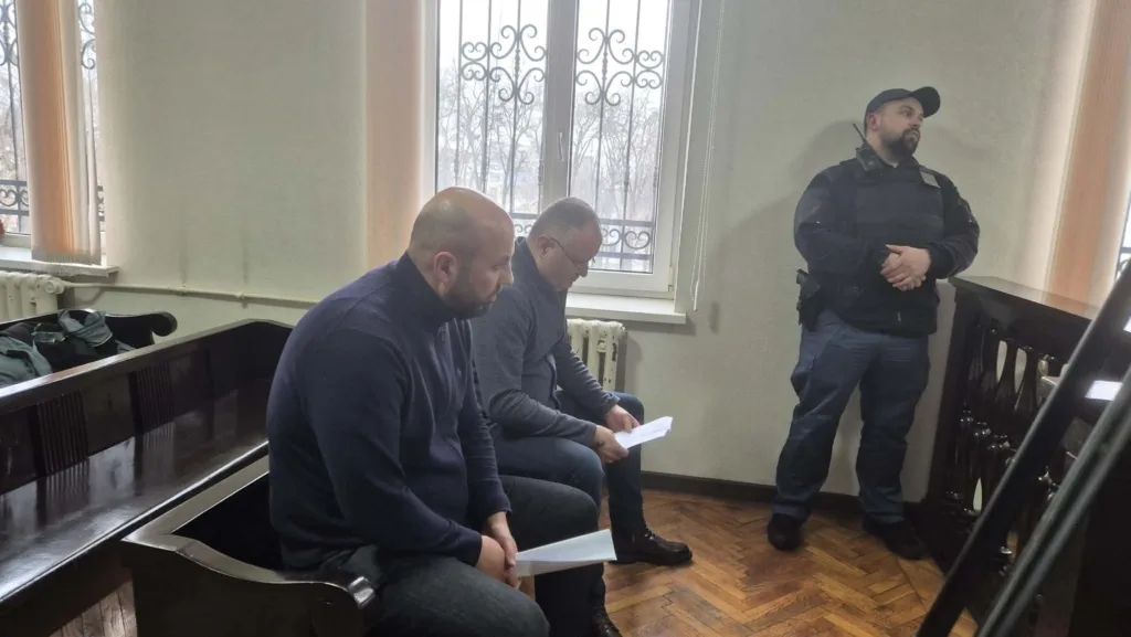 Судове засідання, двоє чоловіків і охоронець