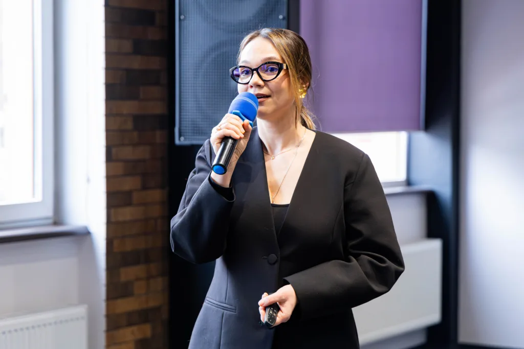 Жінка говорить у мікрофон під час презентації