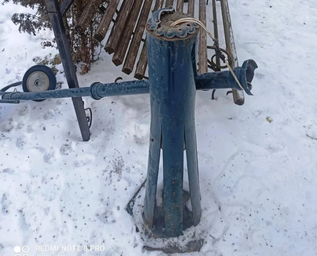 Зламана металева лавка на снігу