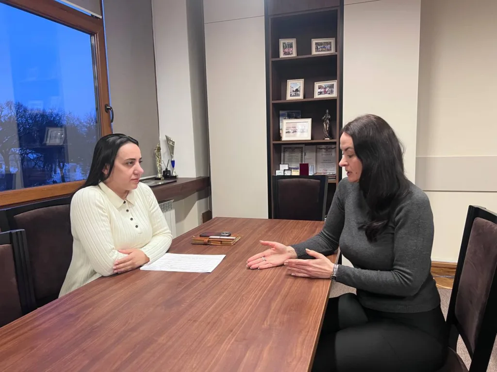 Дві жінки обговорюють документи в офісі