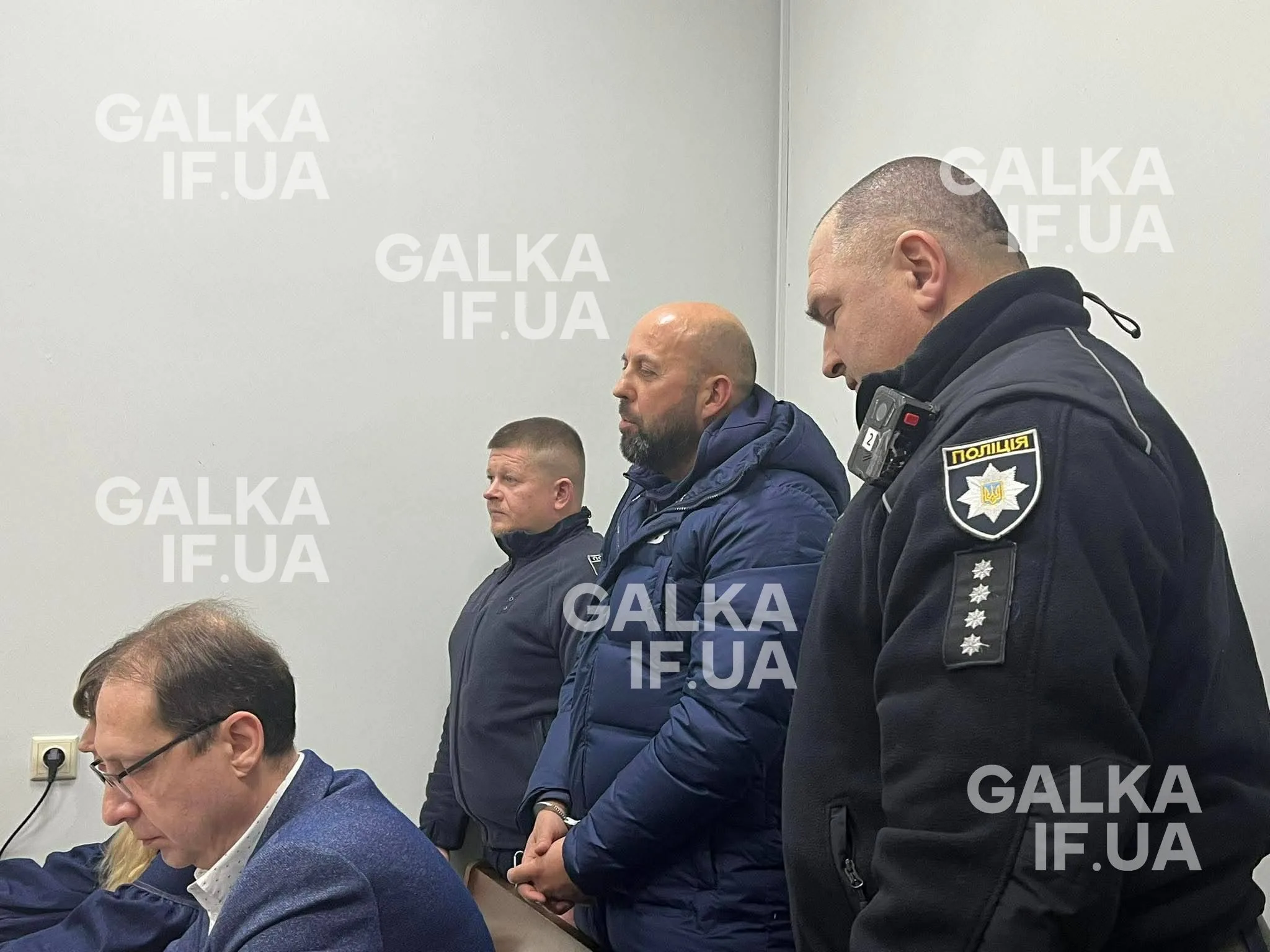 Поліцейські та чоловіки у залі суду