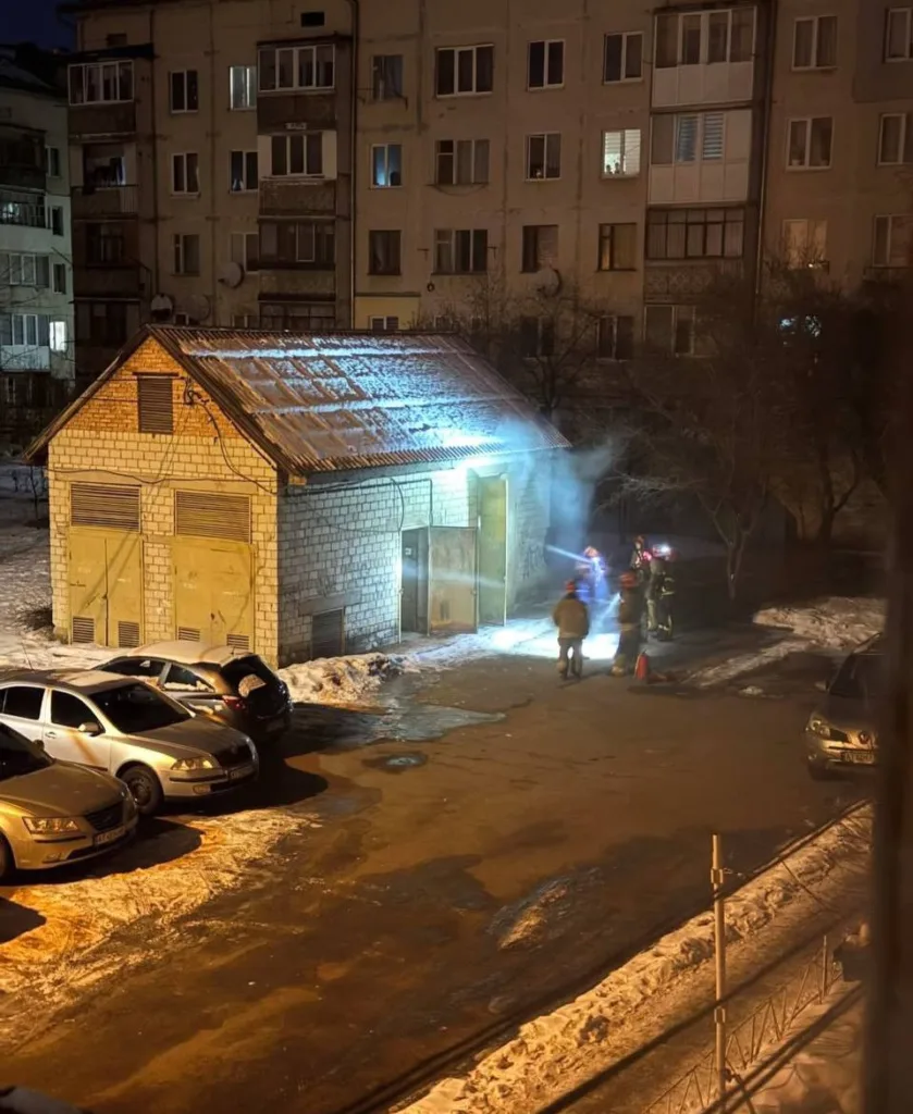 Пожежники гасять вогонь біля гаража взимку