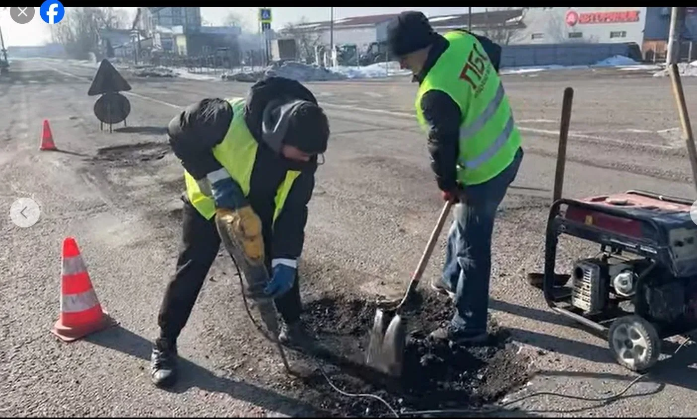 Робітники ремонтують асфальт на дорозі взимку