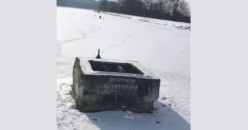 Замерзла річка з бетонною спорудою взимку