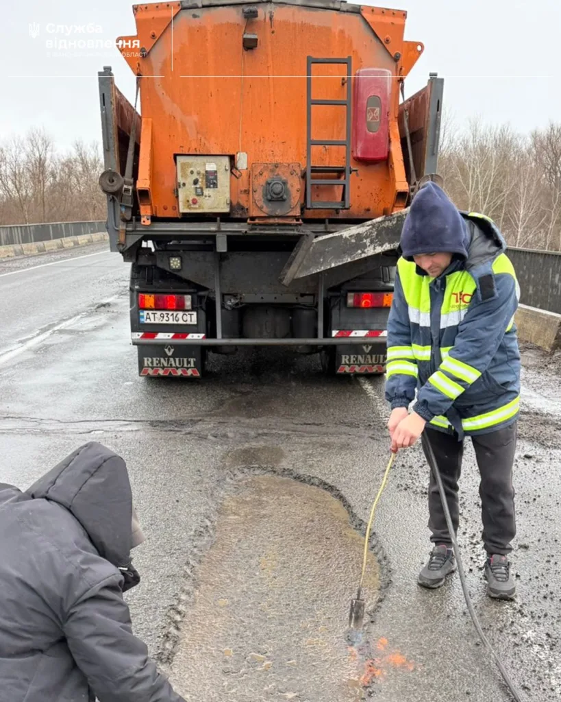 Ремонт дороги працівниками з технікою на мосту