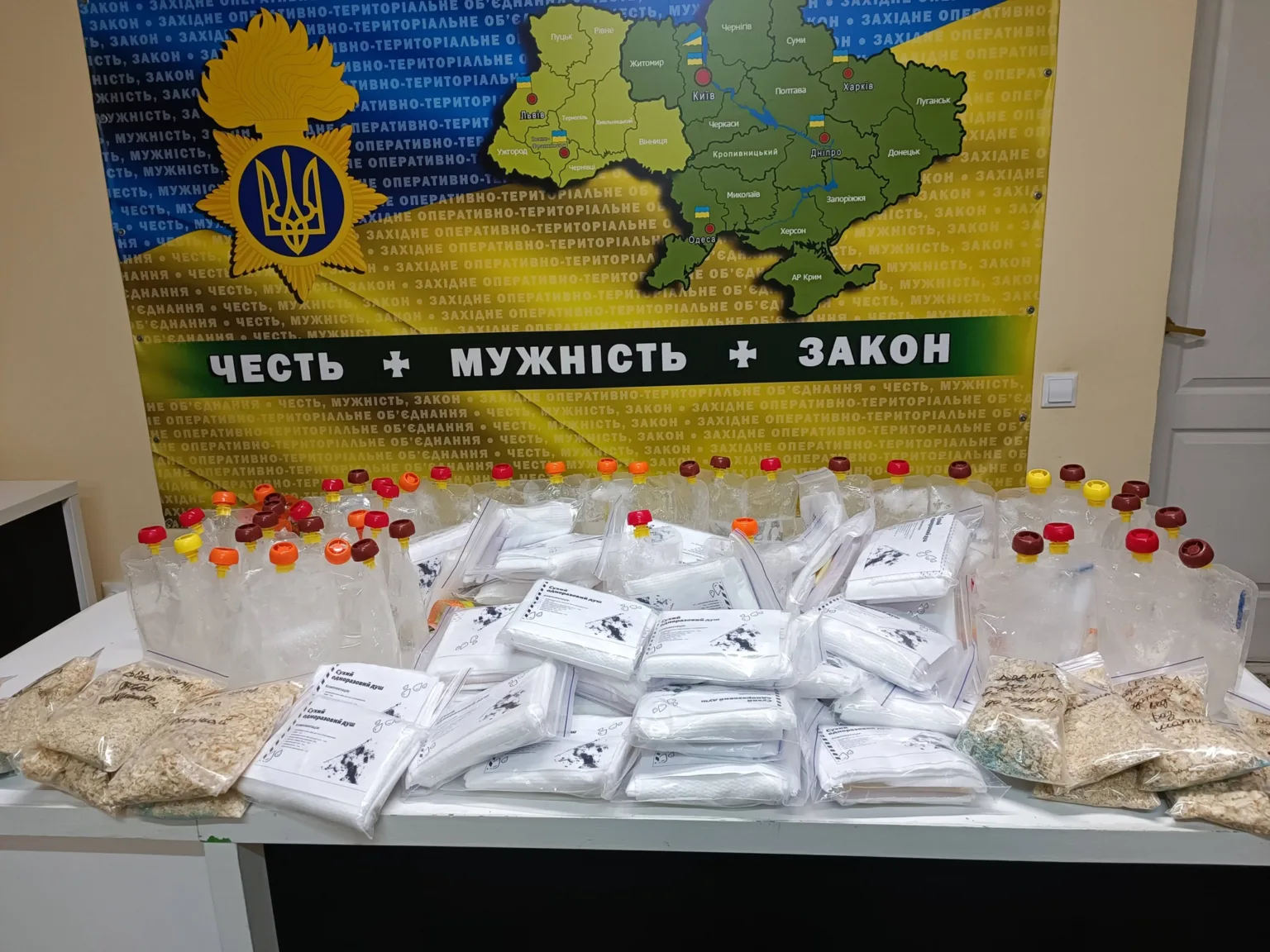 Конфісковані пакунки з порошками перед мапою України