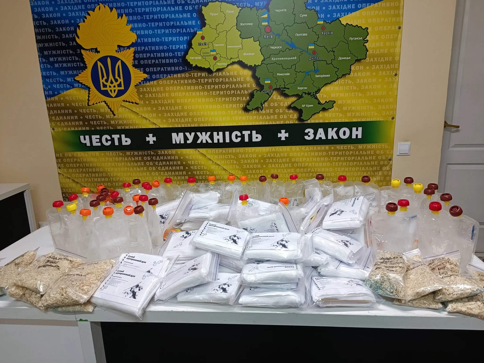 Конфісковані пакунки з порошками перед мапою України