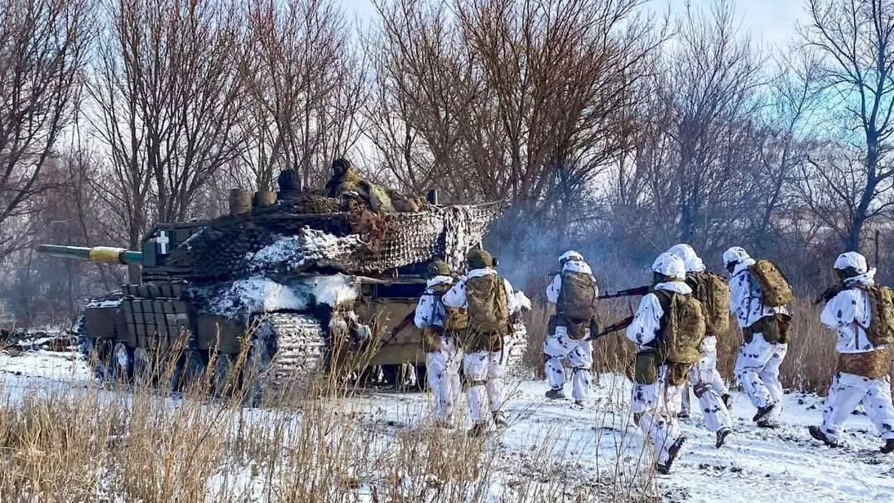 Військові біля танка взимку на полі