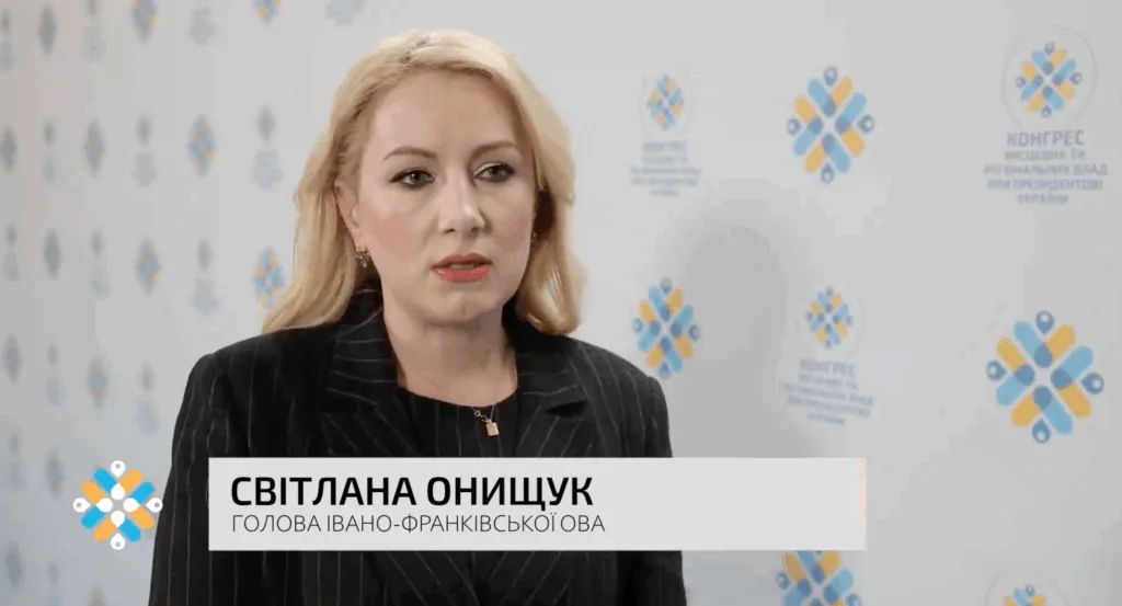 Жінка дає інтерв'ю на фоні логотипів конгресу